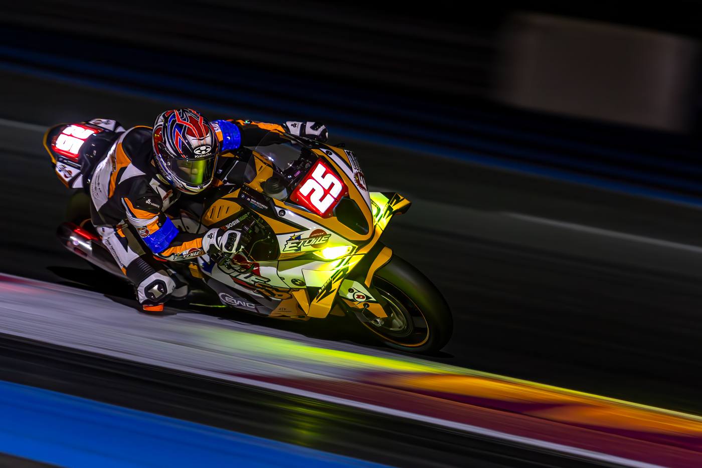 Moto #25 Étoile Racing en panning la nuit au Bol d'Or 2025, couleurs de piste reflétées