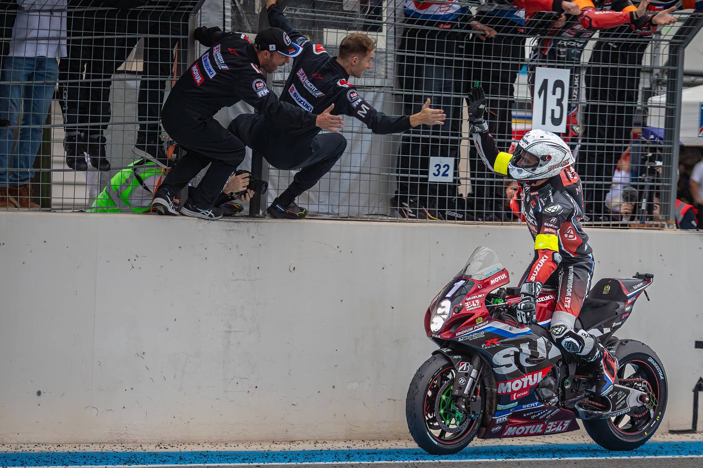 Pilote Suzuki high five avec mécanicien après l'arrivée du Bol d'Or 2025