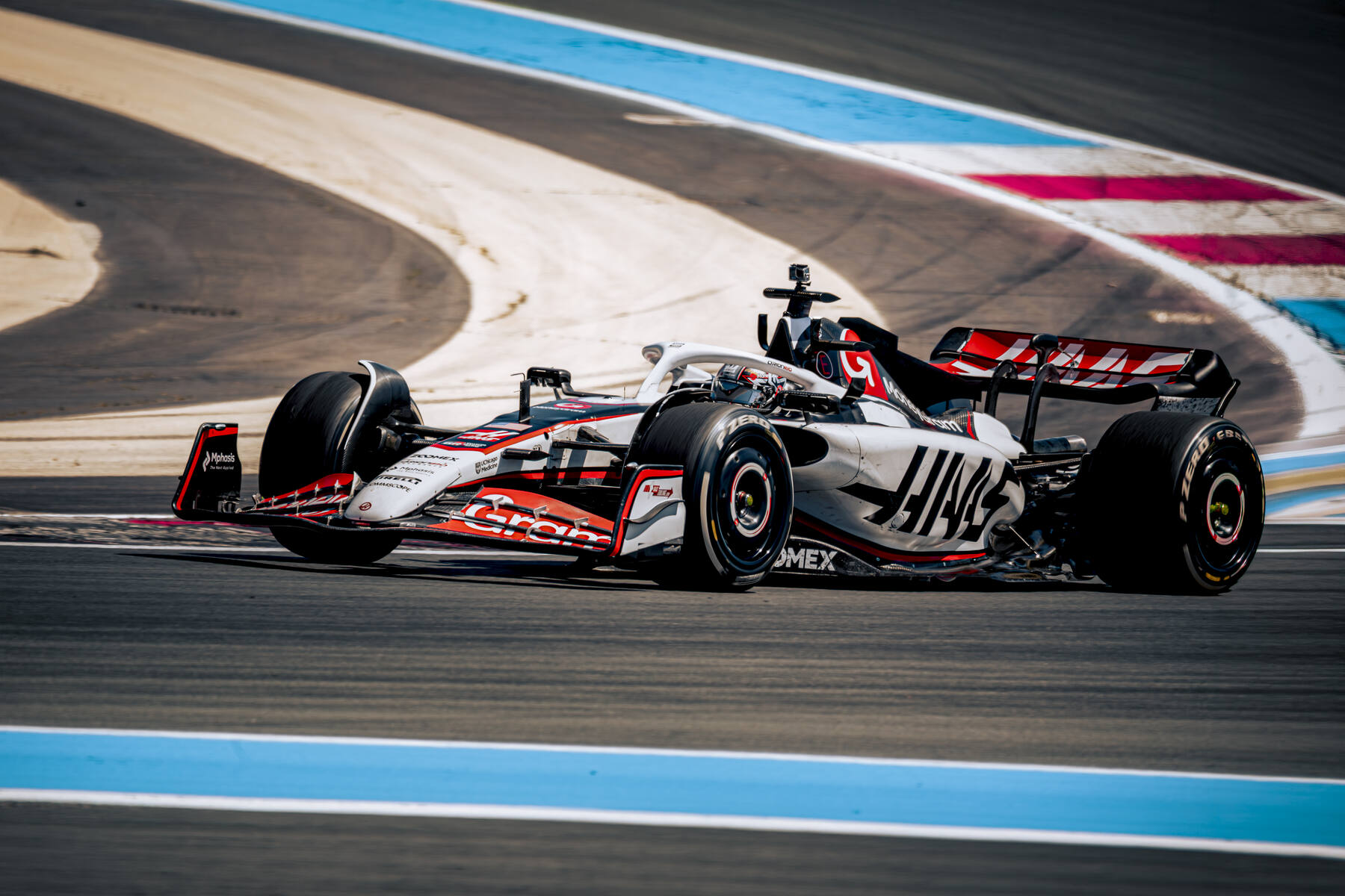 Haas VF-23 en virage vue arrière trois quarts, aileron arrière Haas dominant, Circuit Paul Ricard test 2025