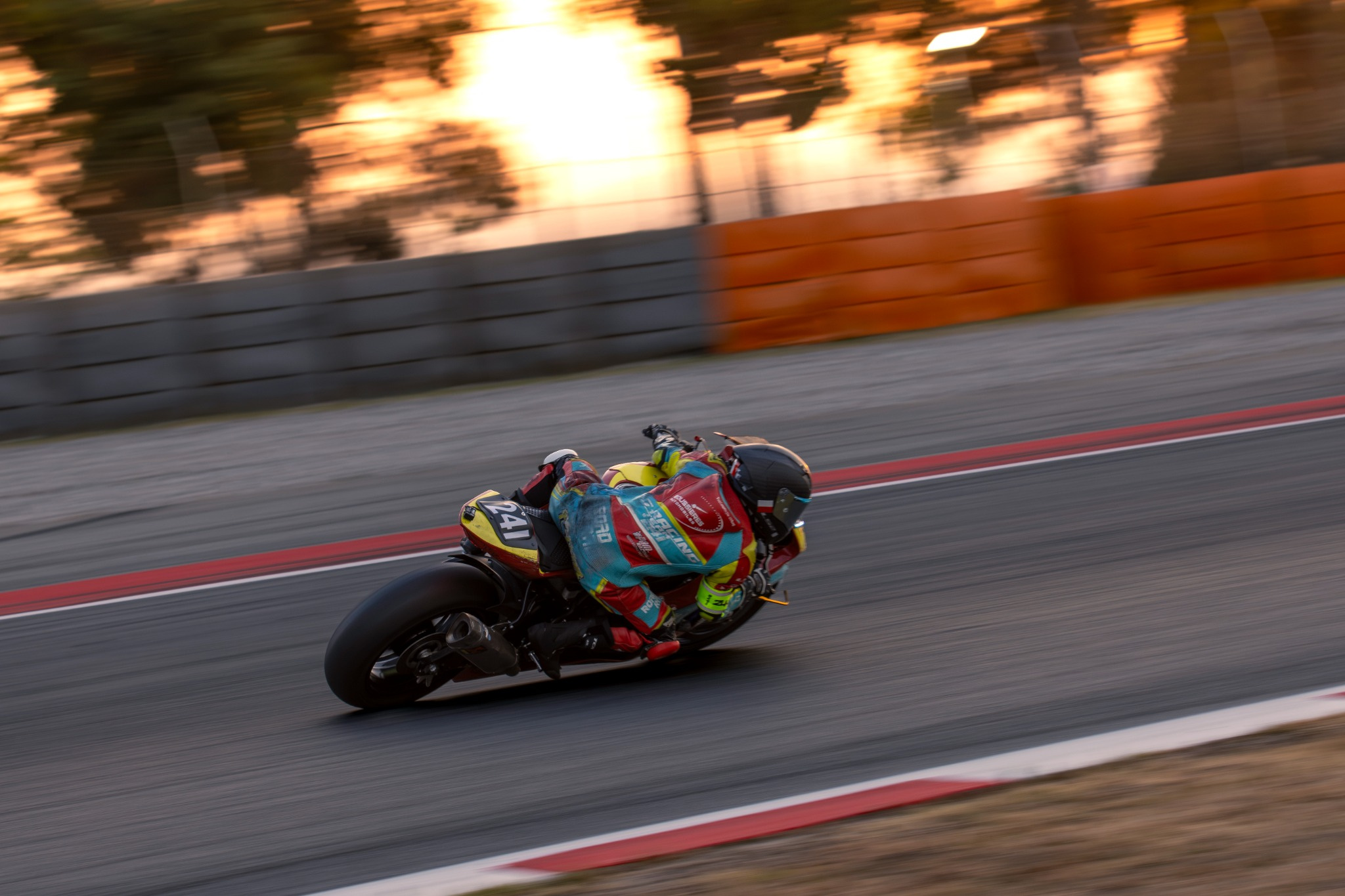Moto numéro 33 photographiée en filé dans la lumière orange du coucher de soleil