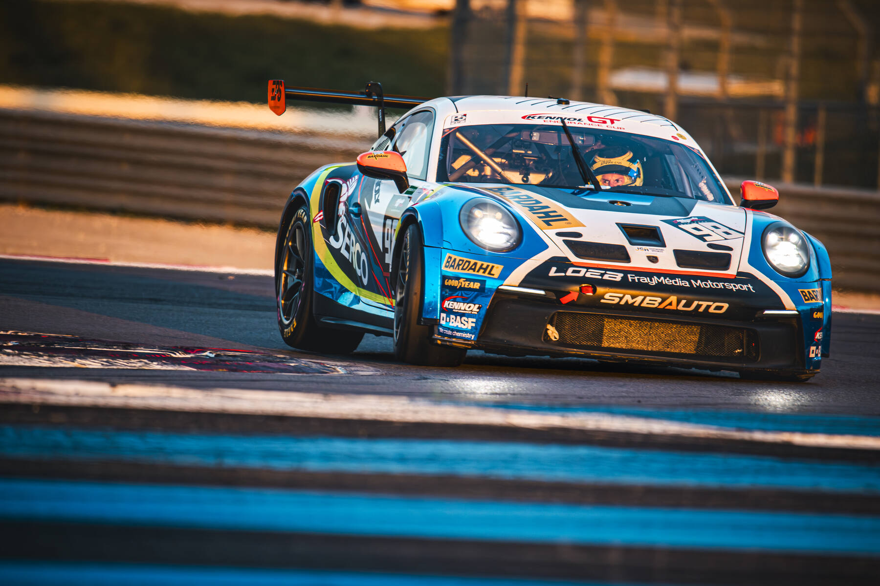Porsche 911 GT3 bleue blanche SMBAuto Loeb FrayMedia Motorsport en virage au coucher du soleil, UCES 2025 Paul Ricard