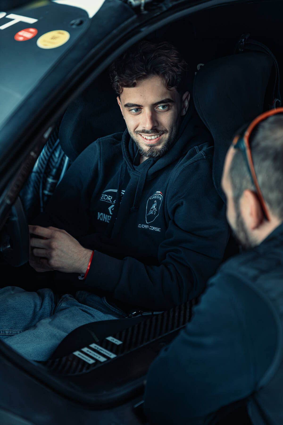 Portrait de jeune pilote souriant dans son habitacle, sweat Squadra Corse, Ultimate Cup Series 2025 Paul Ricard