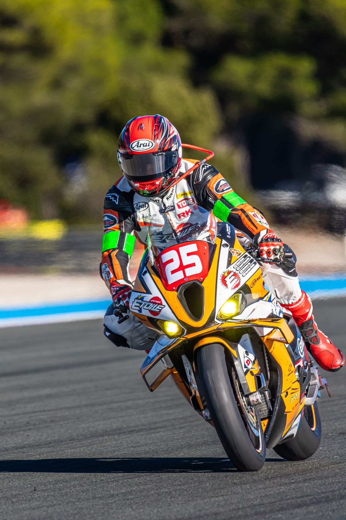 Moto orange n°25 en plein virage, Etoile Japan