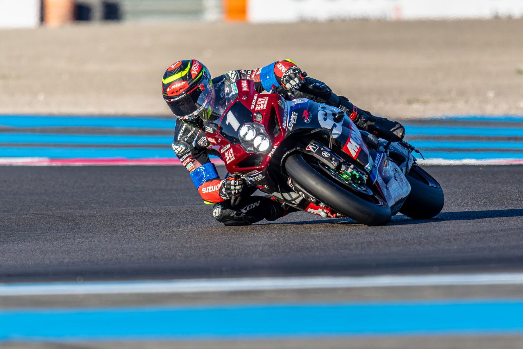 Moto Suzuki n°1 en tête de peloton, virage serré