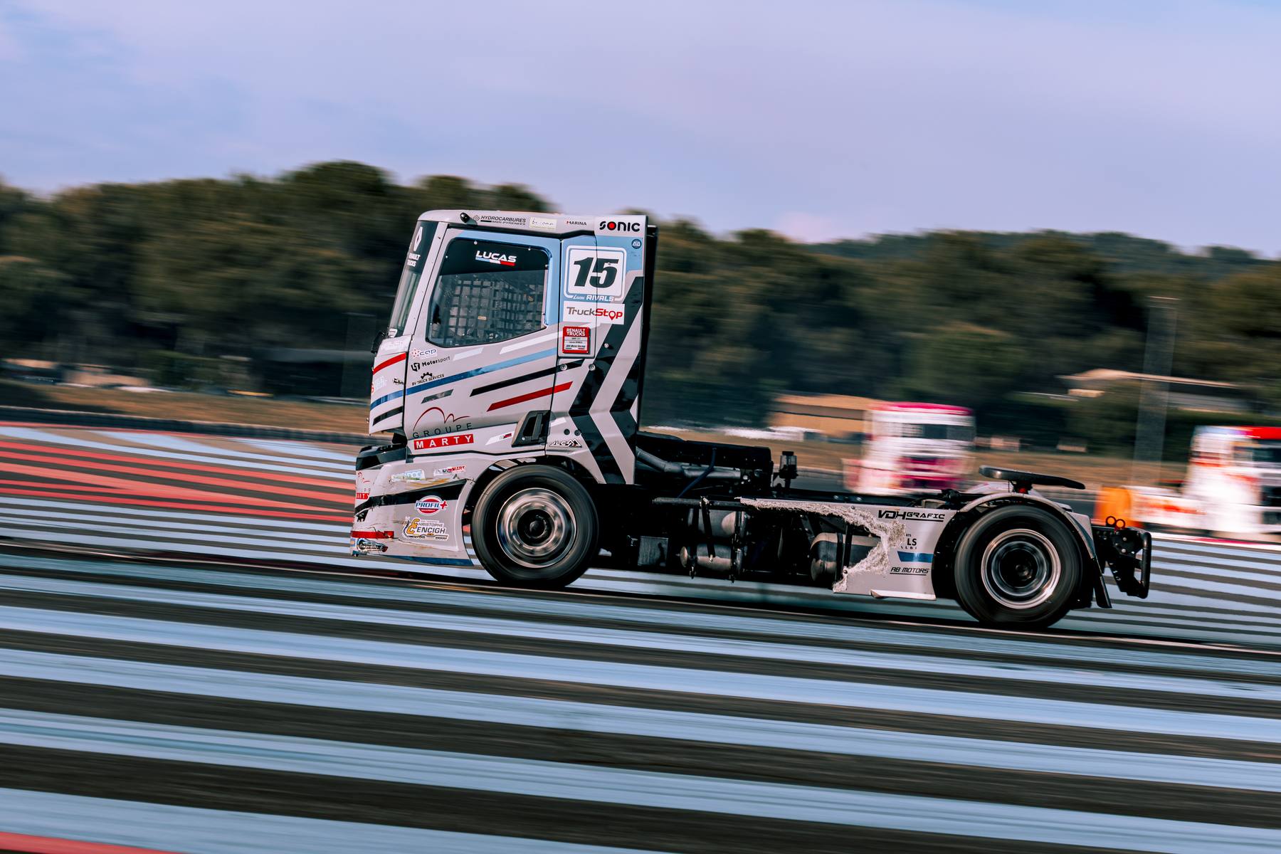 Camion n°15 noir en filé, sortie de virage