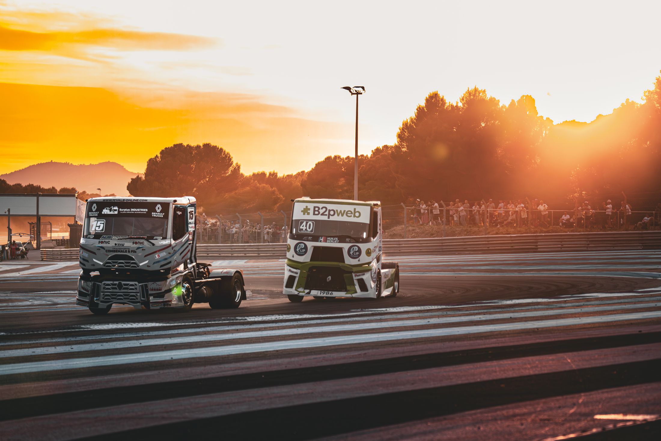 Deux camions à contre-jour, coucher de soleil sur le circuit