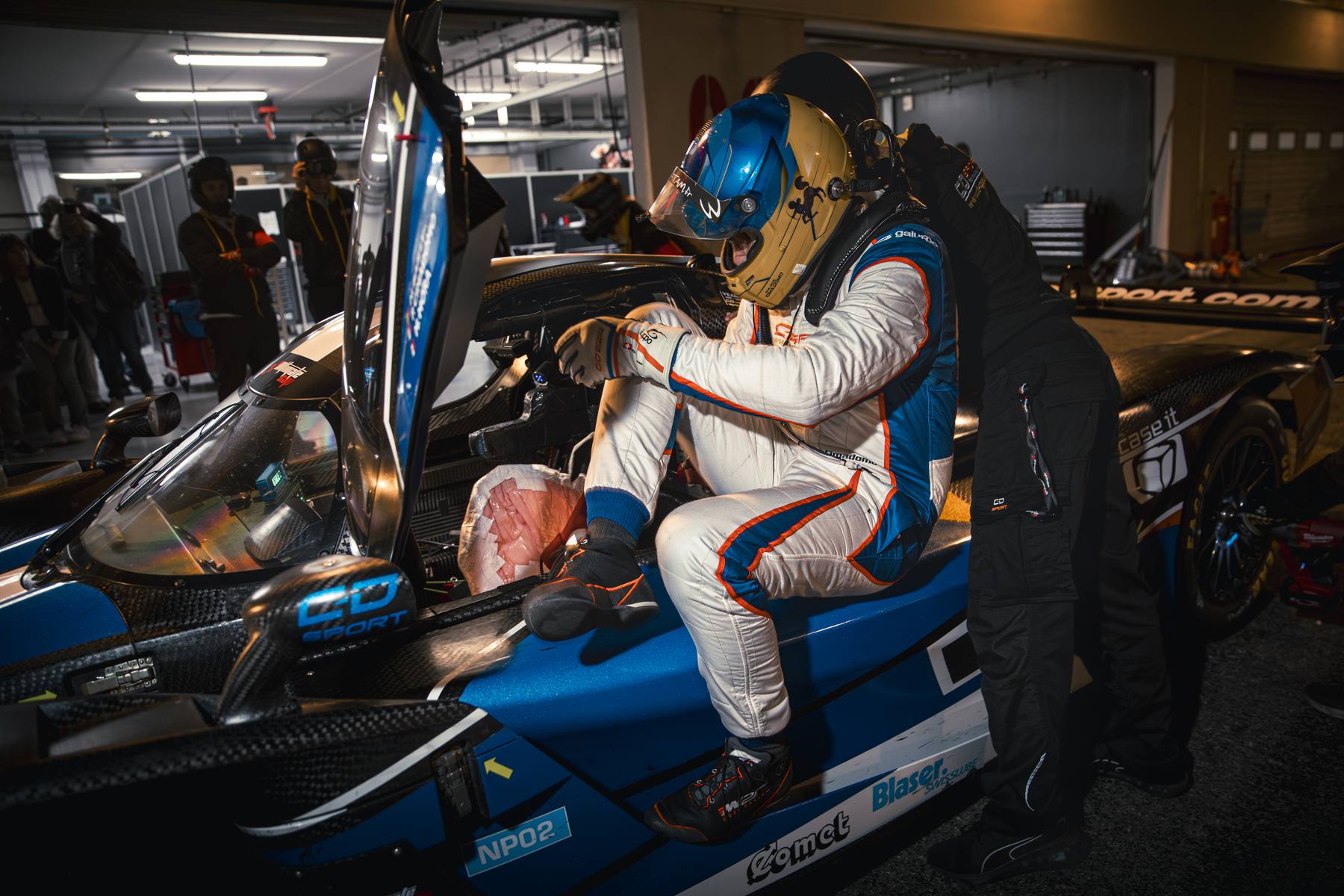 Pilote en combinaison dans le cockpit, prototype dans la voie des stands