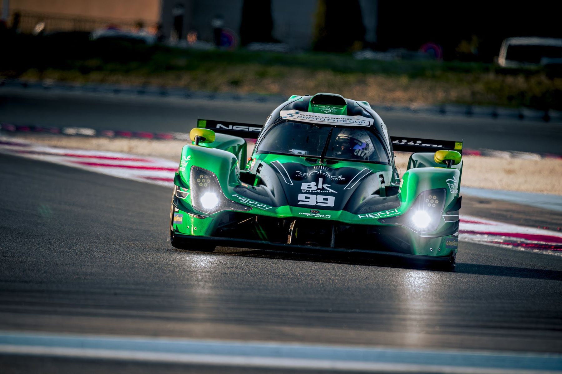 Prototype vert n°99 en virage, phares allumés