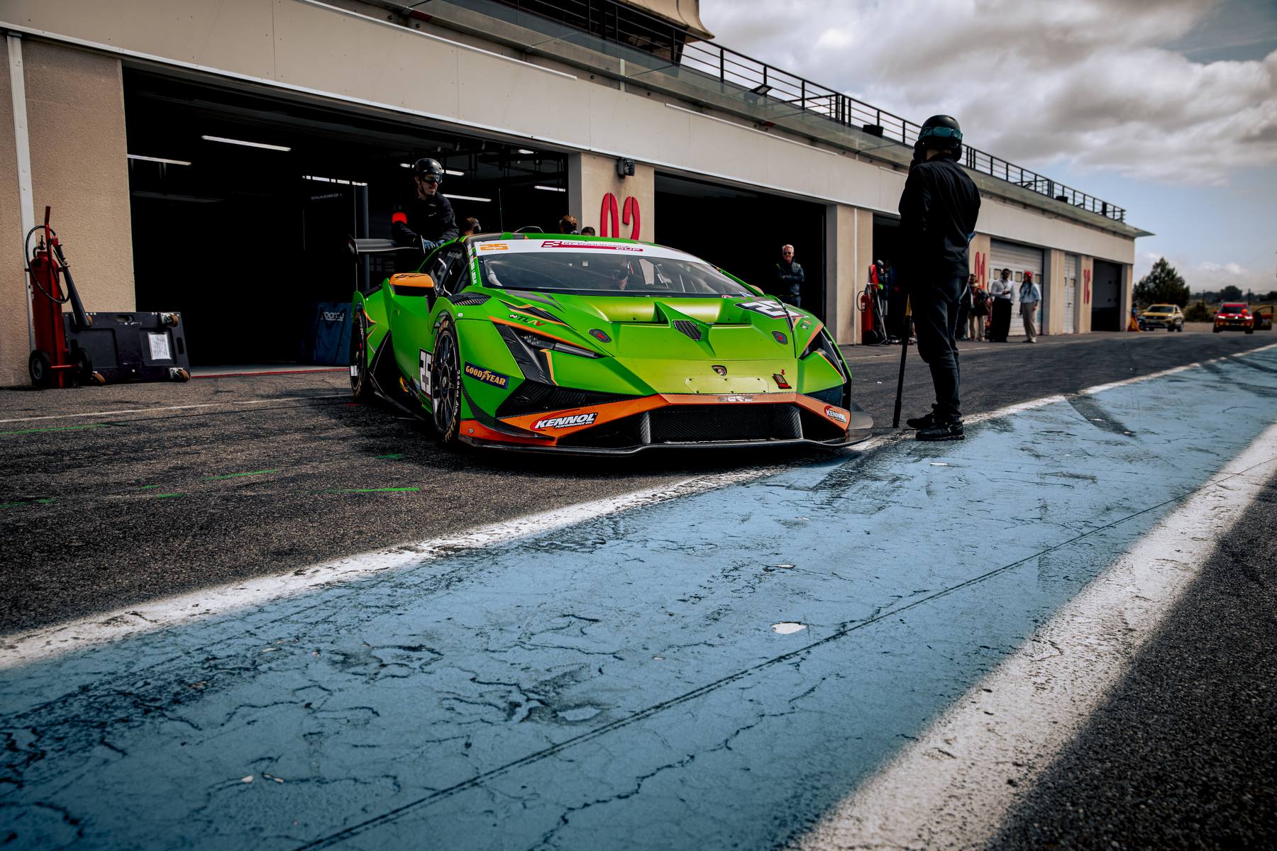 Lamborghini Huracán verte et orange en sortie de stand