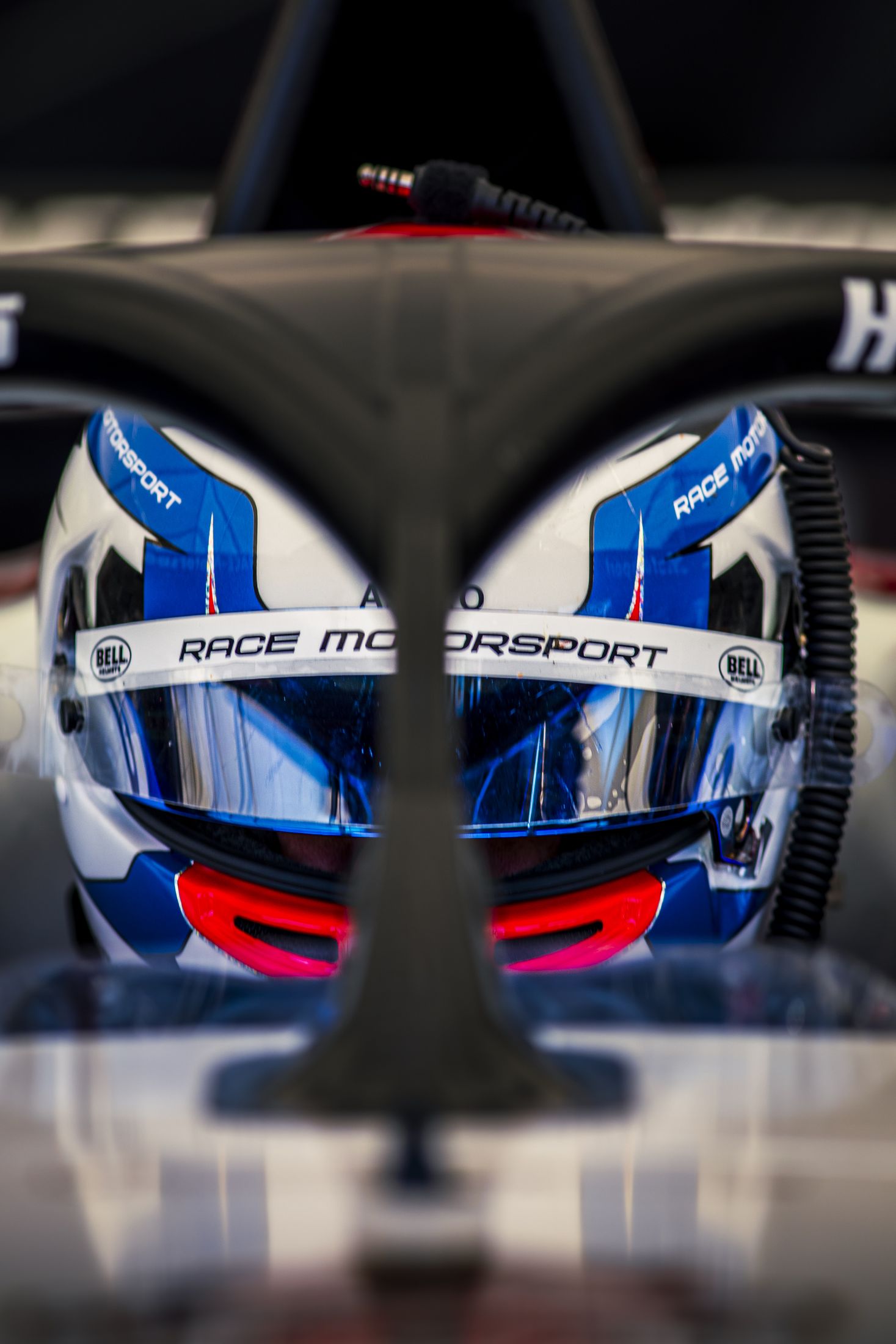 Portrait pilote dans le cockpit, casque bleu Race Motorsport