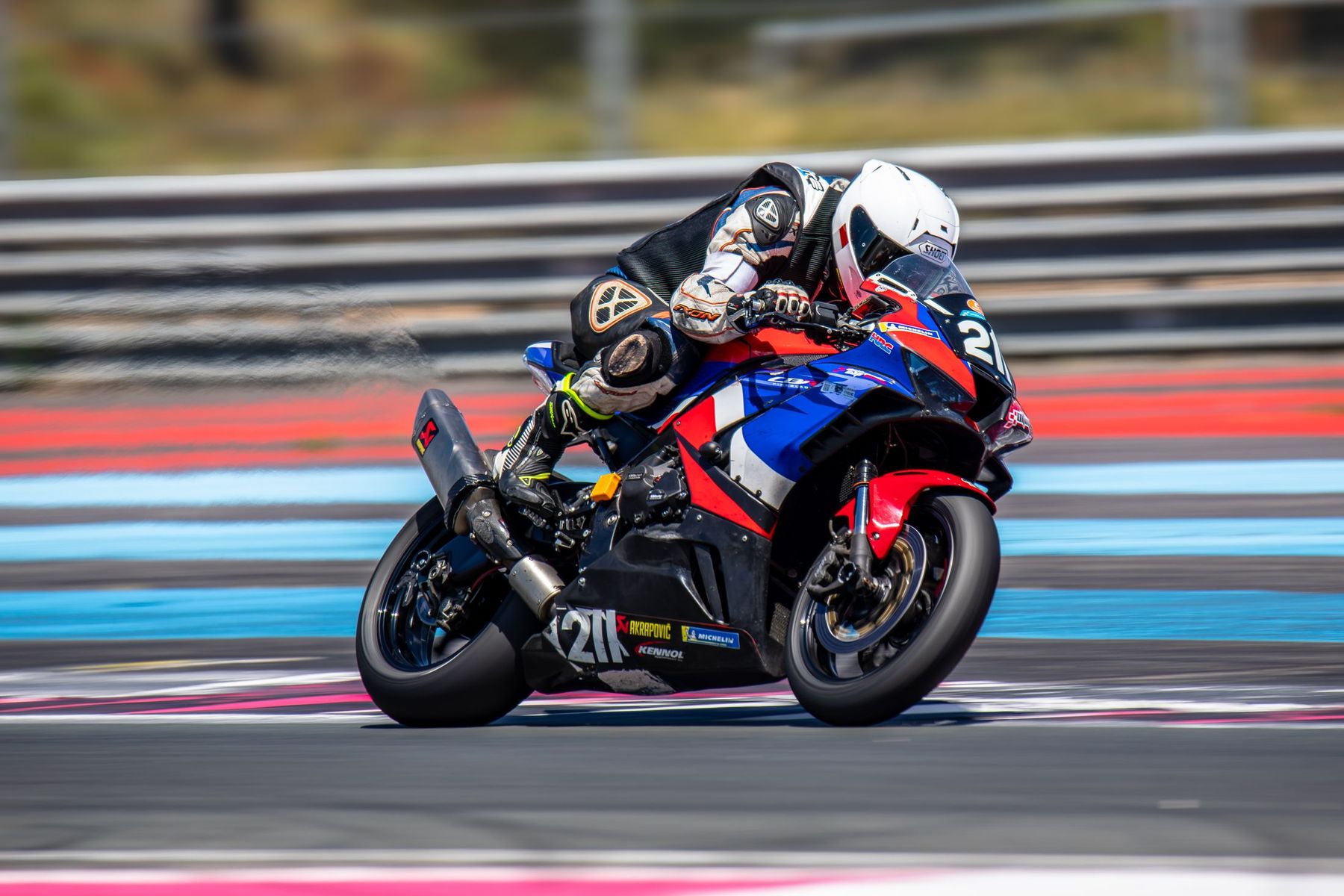 BMW rouge et bleue n°21 en pleine inclinaison