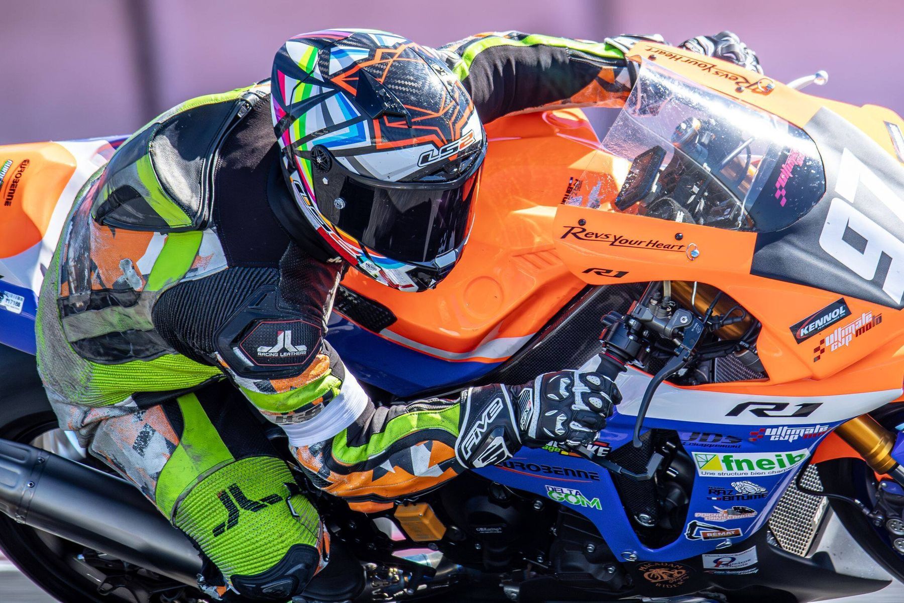 Pilote sur Yamaha R1 orange, vue cockpit rapprochée