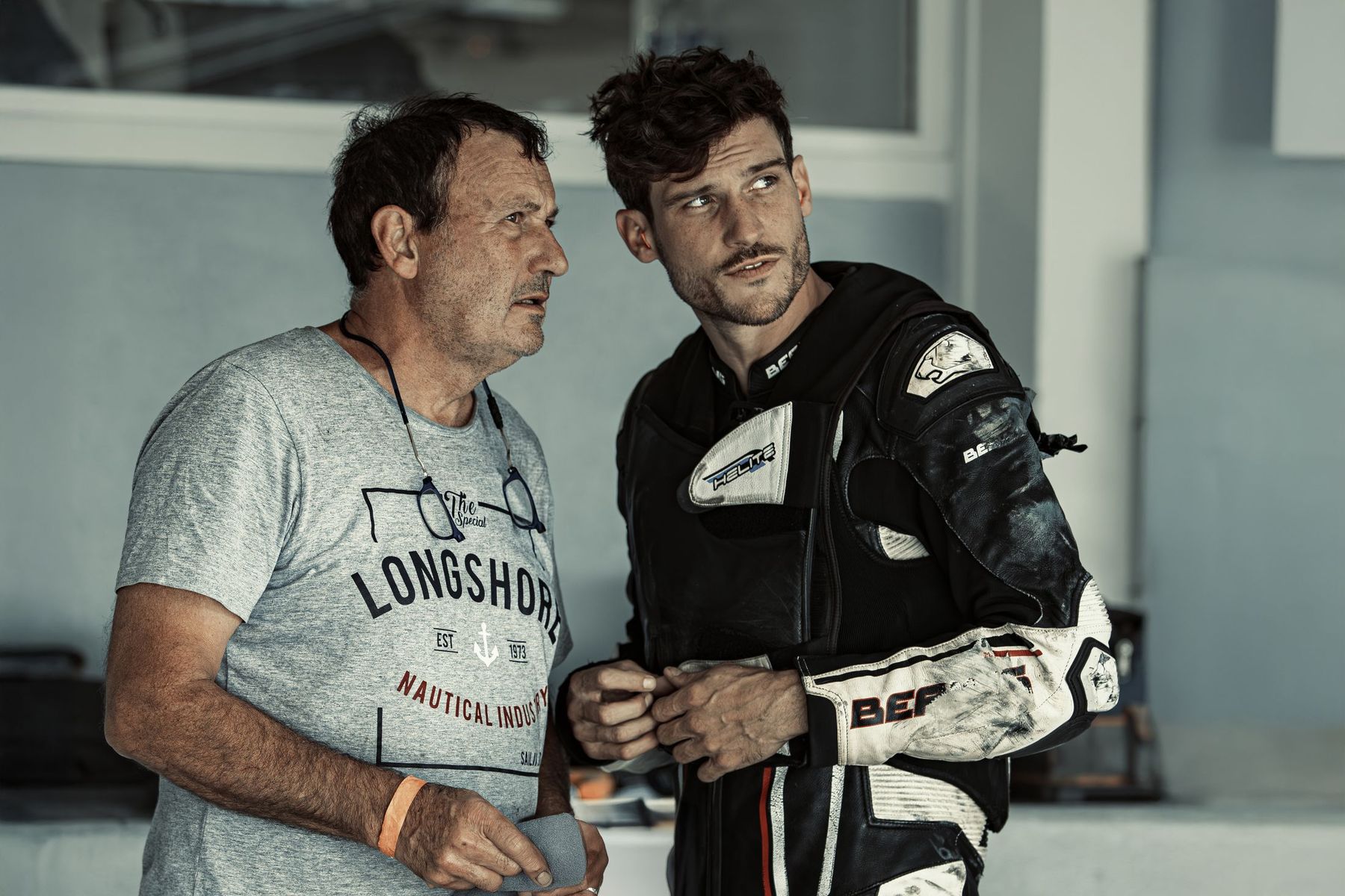 Pilote et team manager en conversation dans le paddock