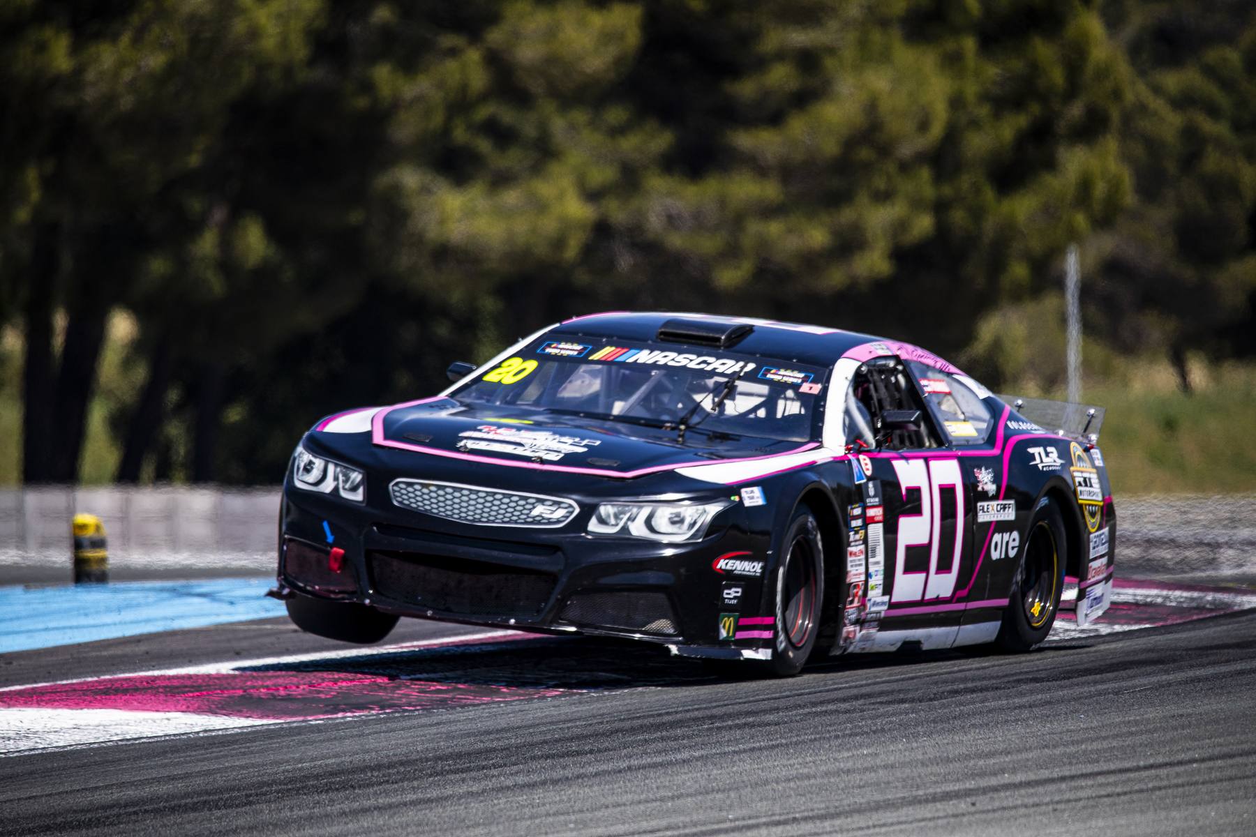 Stock-car bleu marine et rose n°20 en virage