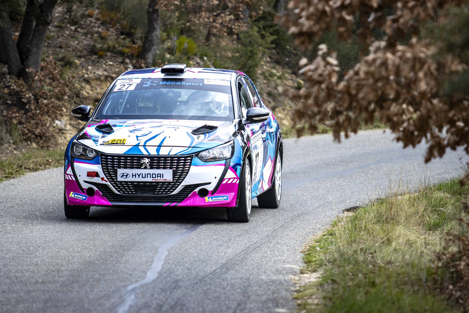 Peugeot 208 rose et noire en virage serré