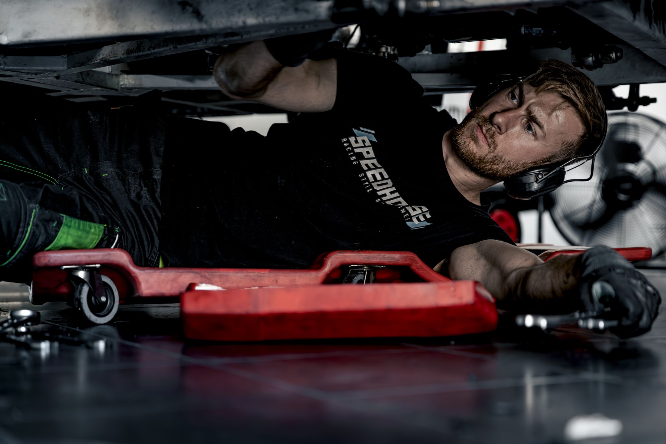 Mécanicien travaillant sur une voiture de course, reportage paddock et stands pour team